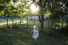 ბავშვი მწვანე ეზოში მორბის